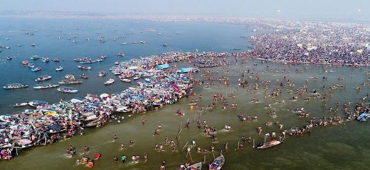 Triveni Sangam Prayagraj showing devotees performing holy rituals and taking a sacred dip at the confluence of the Ganga, Yamuna and Saraswati rivers.